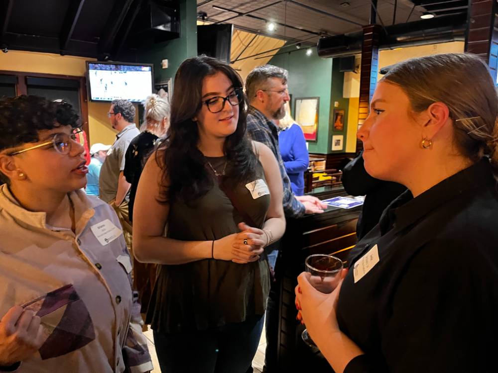 Three alums talking at the event.